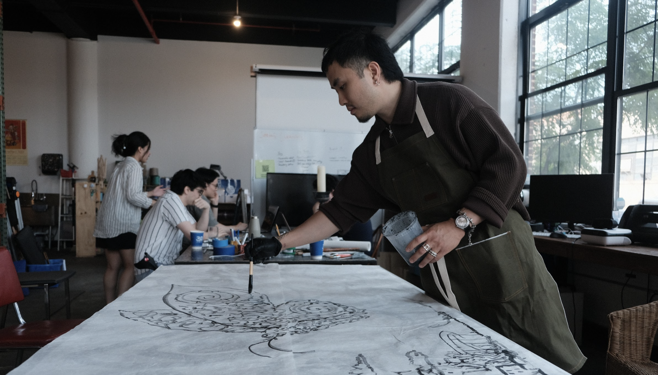 Artist Jeremy Leung is pictured here doing a live ink painting.
